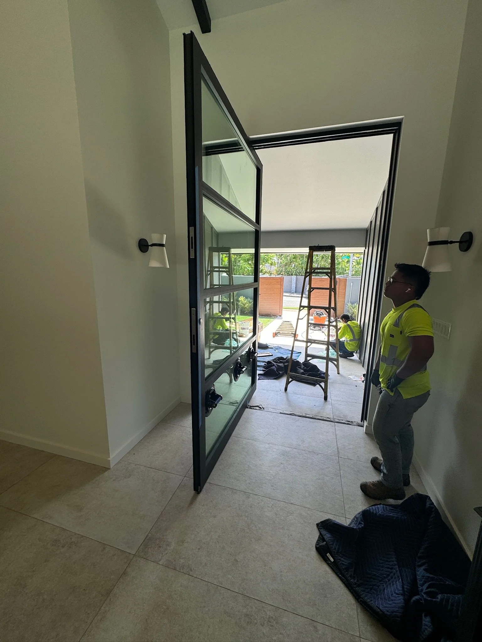 Construction workers installing a glass door in a modern home.