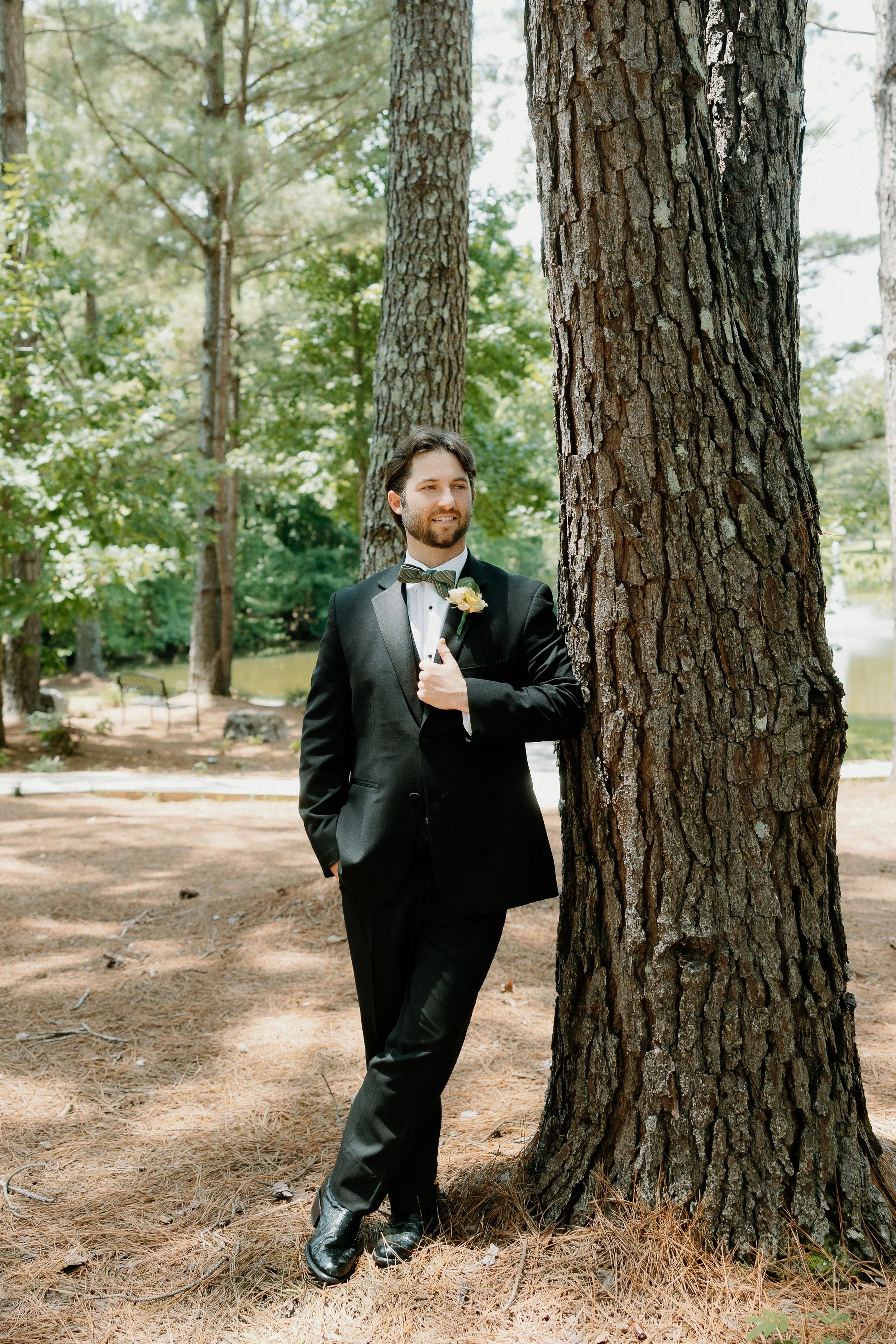 Outdoor Groom's portraits around the grounds of Kingfisher Lodge venue, utilizing beautiful pine trees and outdoor scenery.