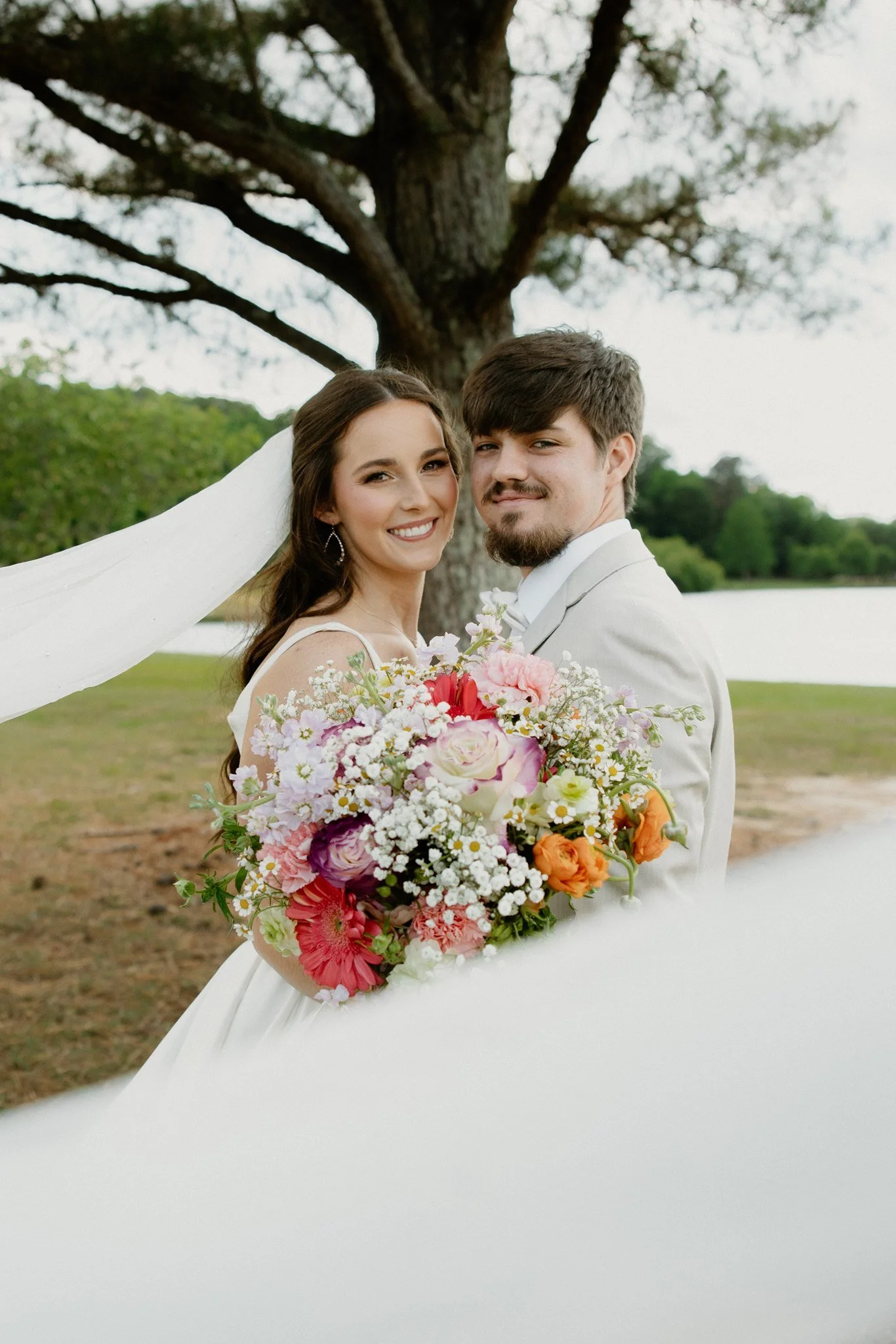 Tupelo, MS wedding bride and groom portrait utilizing veil for foreground, shot by Hannah Ellis Photography