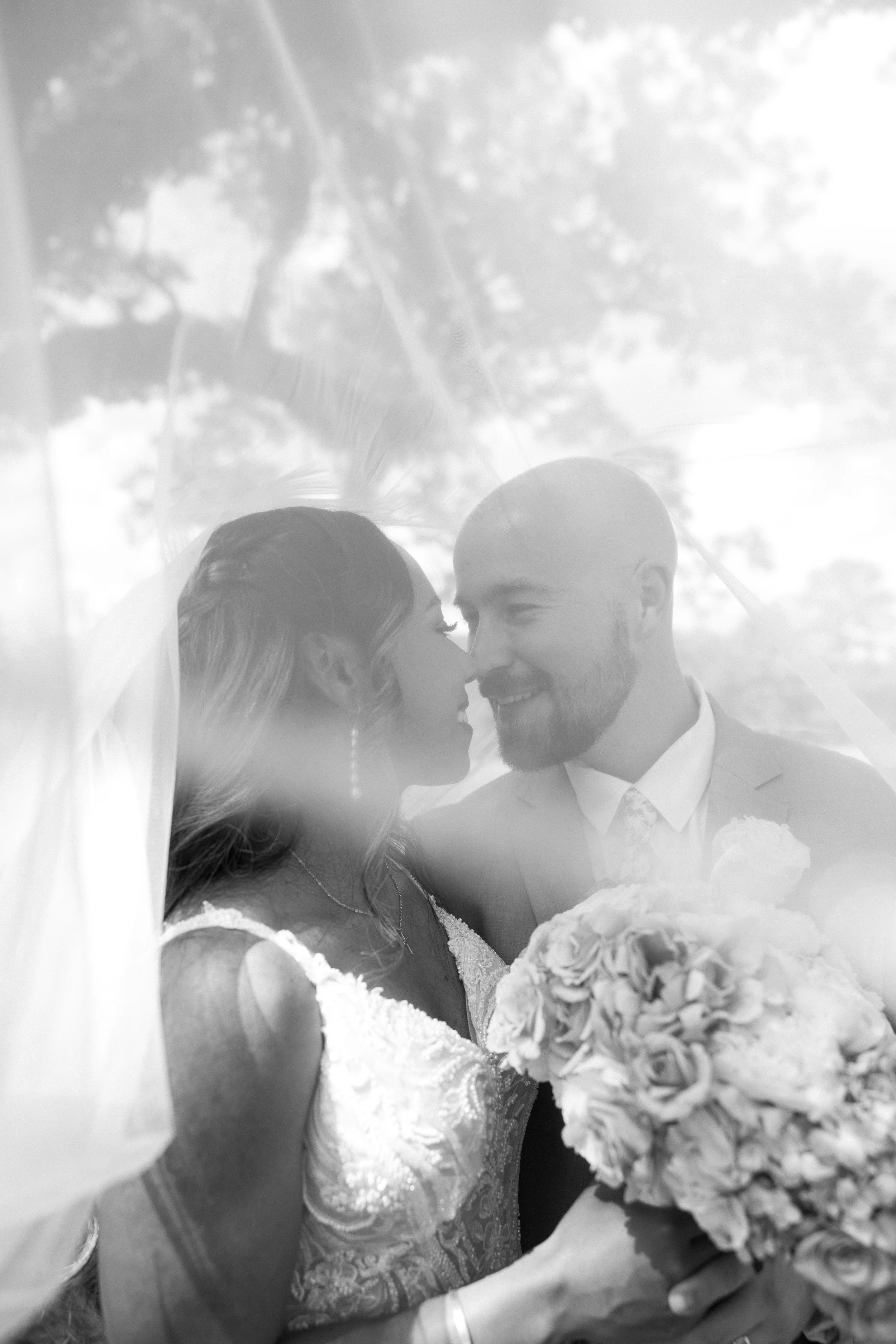 Bride and groom under veil, featured at Dodson Farm wedding venue