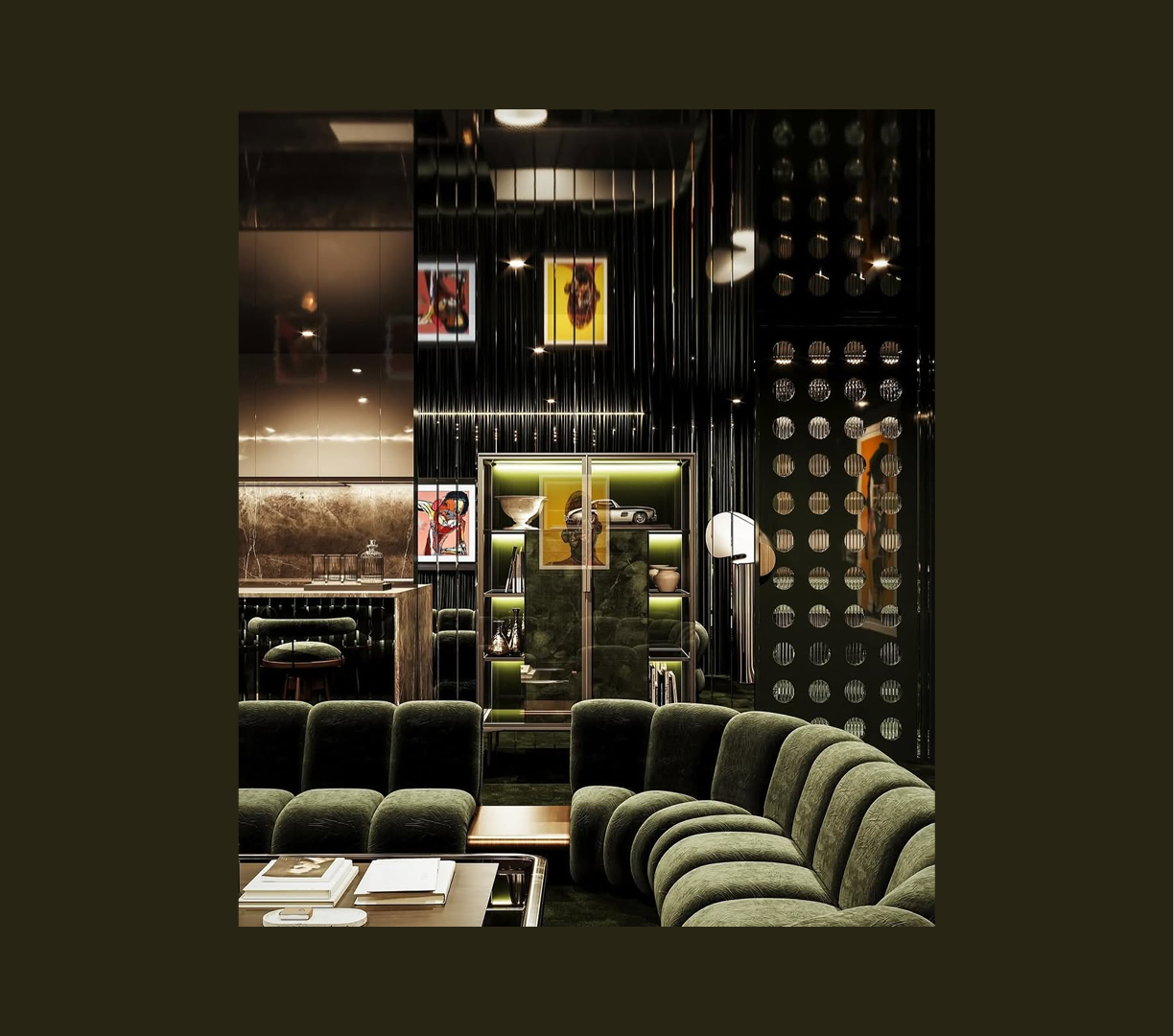 Interior of a modern, stylish lounge or living room with dark walls, green velvet curved sofa in foreground, bookshelf with artwork and decorative objects in background, and art pieces on the wall.
