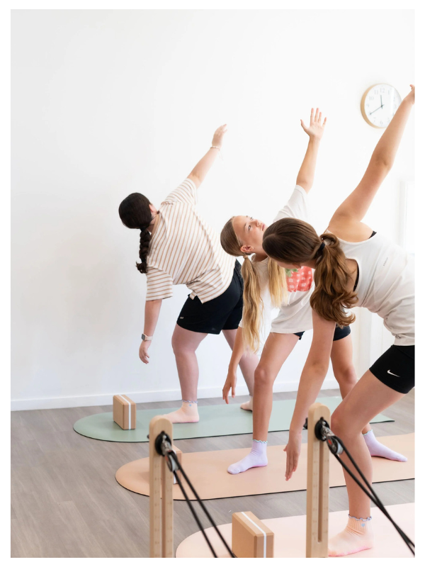 Small-group kids’ reformer Pilates session led by paediatric physiotherapist in Burleigh Waters clinic.
