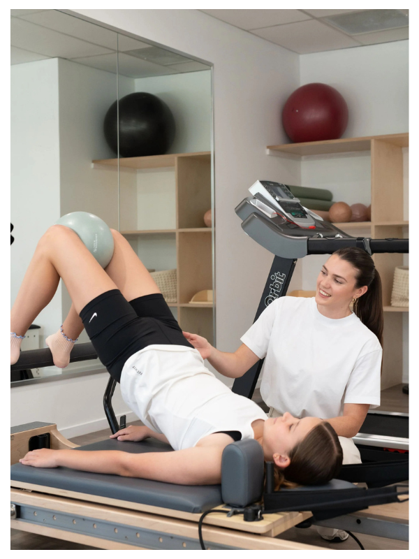 Paediatric physiotherapist supporting a child on a Pilates reformer at Early Years Physiotherapy, Gold Coast clinic.