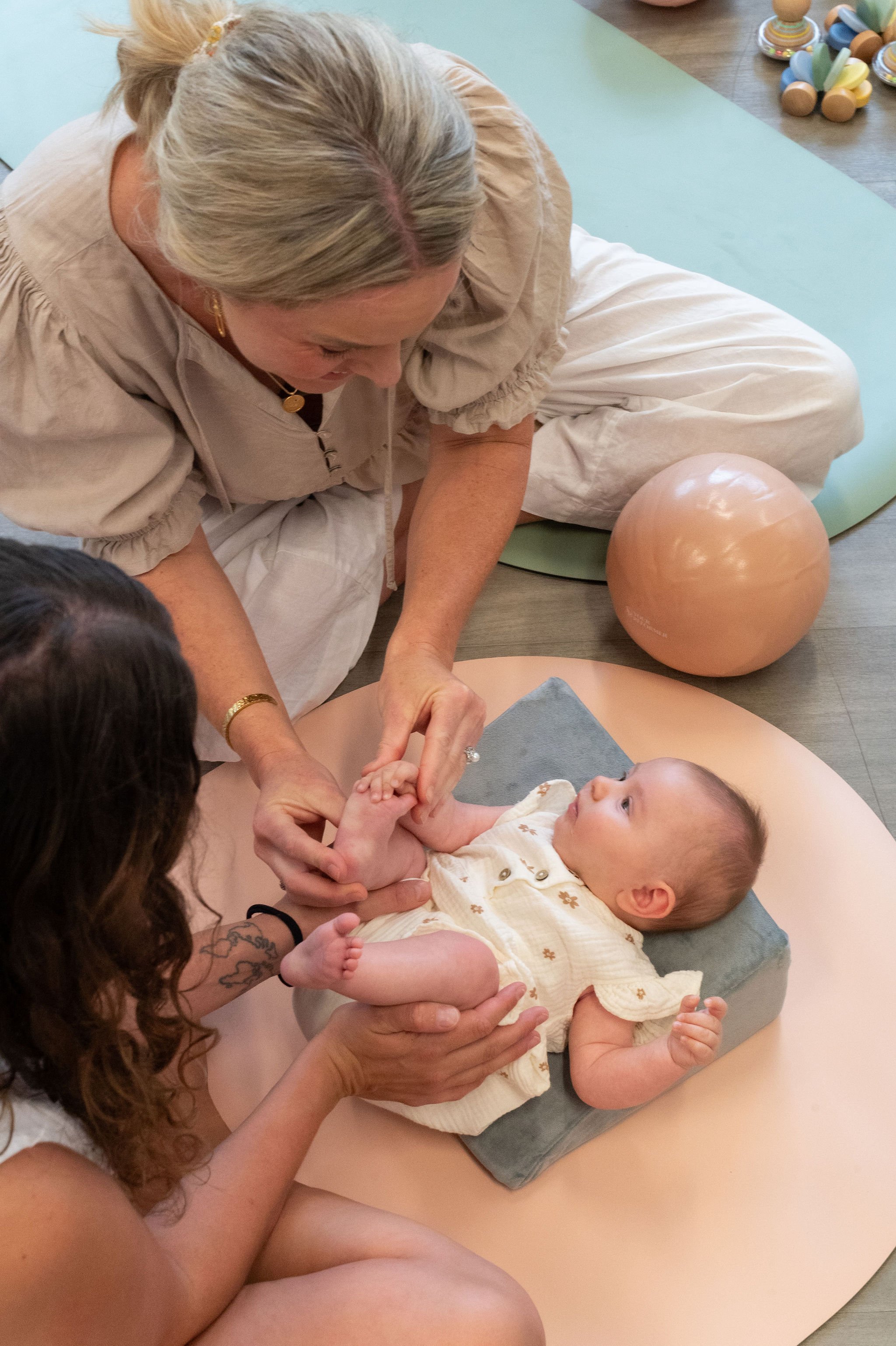 Physiotherapist guiding baby’s feet during a hands-on session in the Nurture & Move group