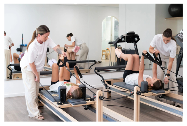 Close-up of child’s feet on reformer footbar with physio guiding safe alignment.