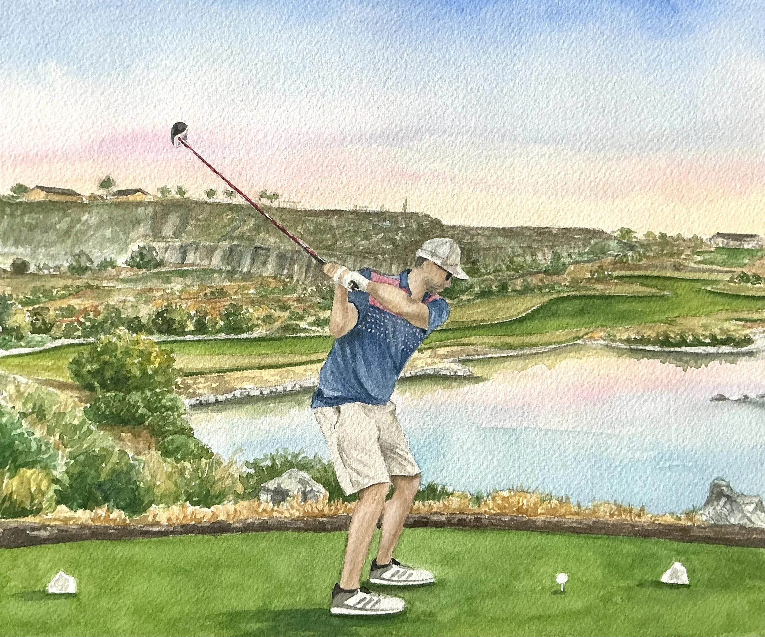 A man in a blue shirt, khaki shorts, and a white cap is swinging a golf club on a green golf course with a pond and scenic hills in the background.