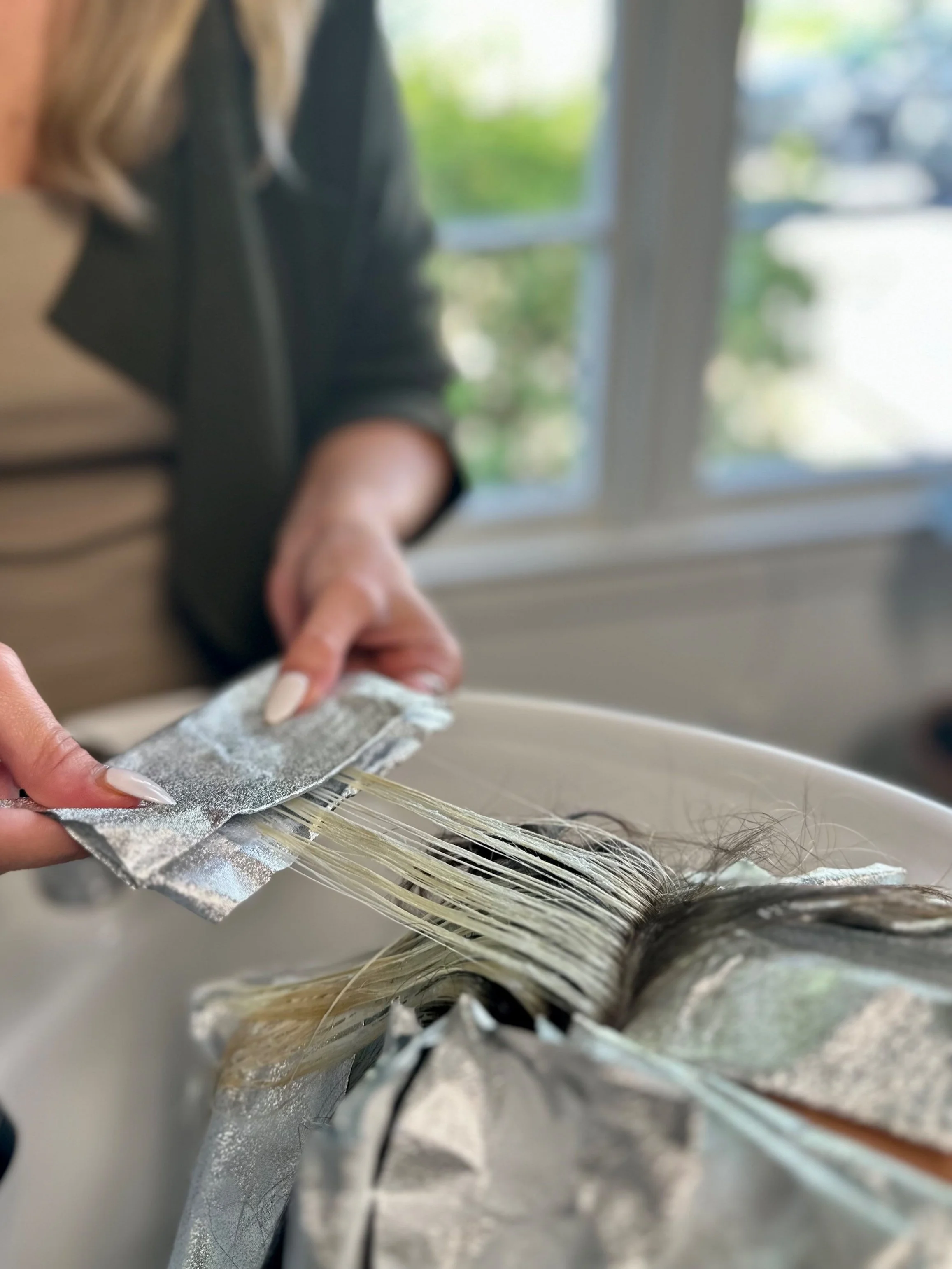 Hairdresser applying hair foil for highlights