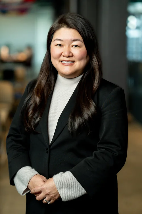 Team headshot of a woman in a black blazer at a San Francisco tech office