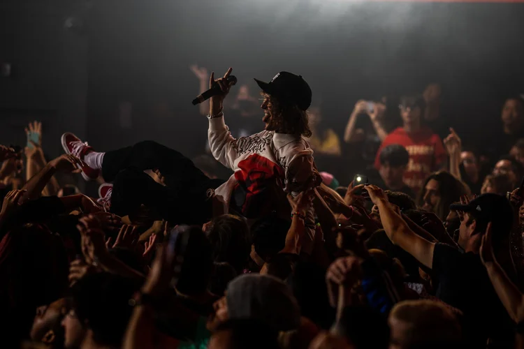 Crowd with hands raised for a performer at Academy LA
