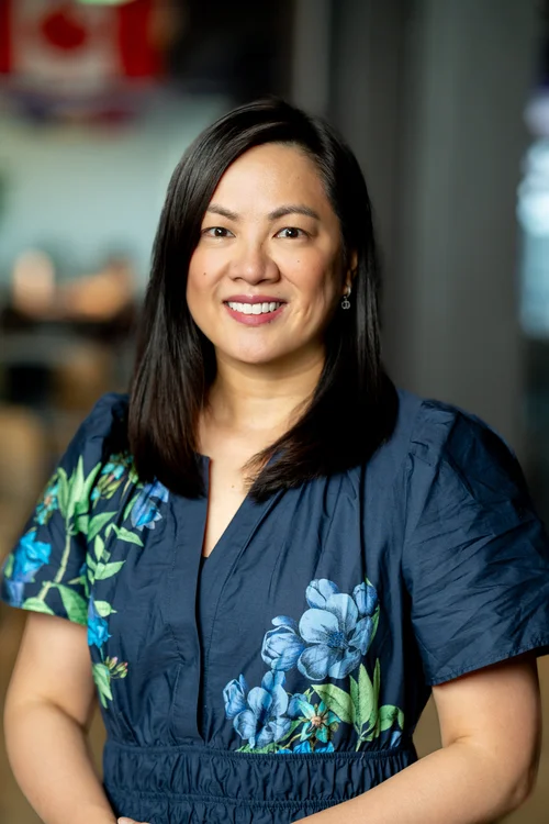 Team headshot of a woman in a floral dress at a San Francisco tech office