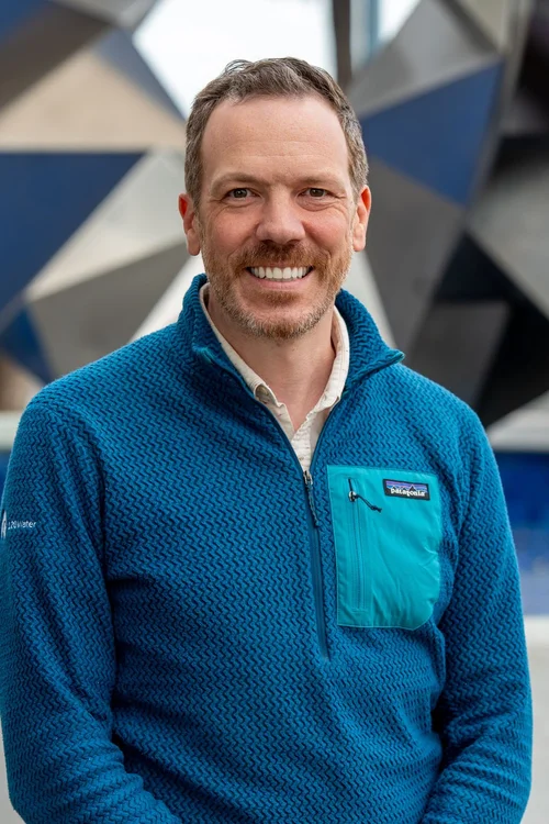 Team headshot of a man in a teal fleece jacket outdoors in the Bay Area