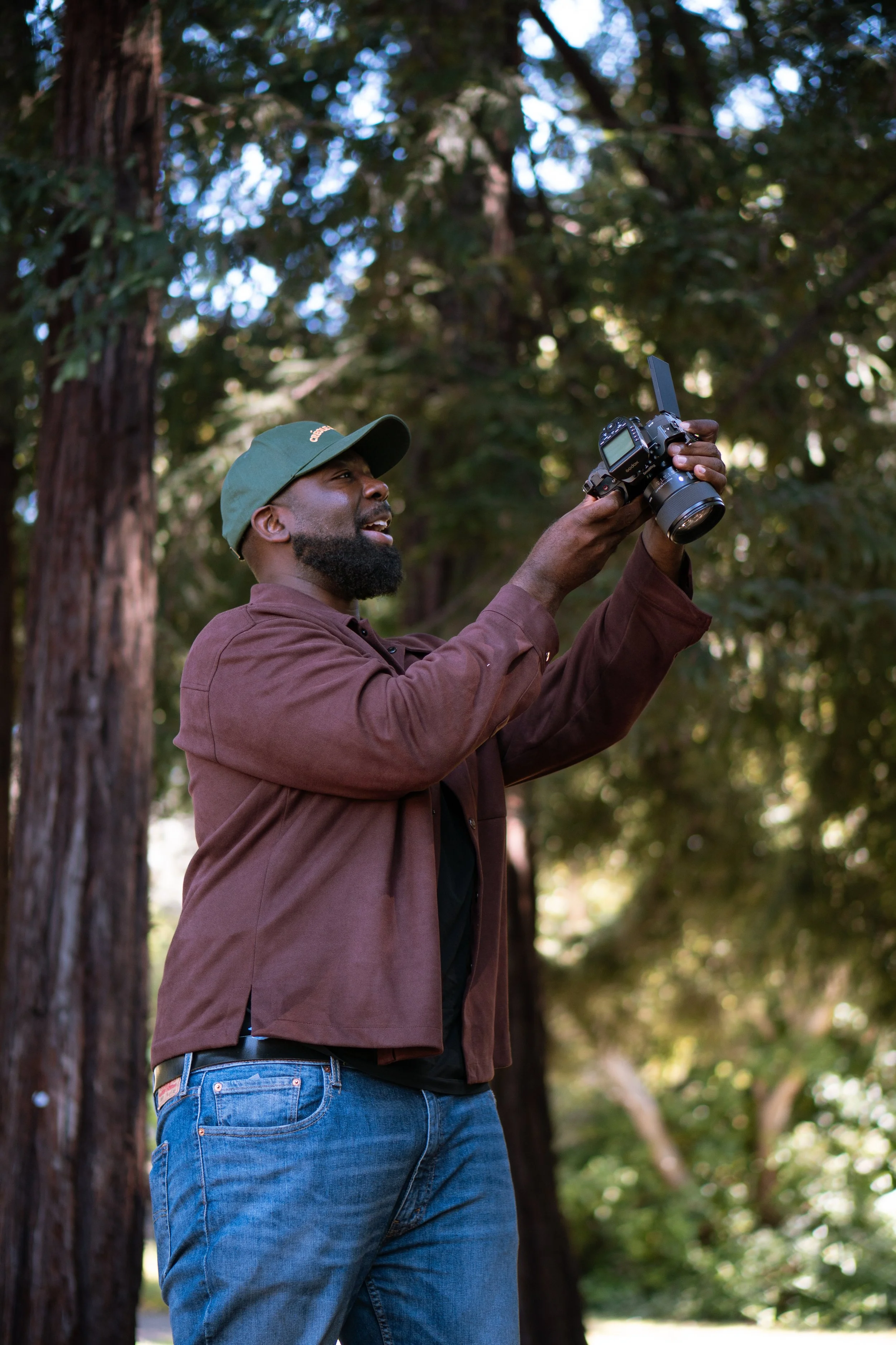 Kofi Dodi, corporate and conference photographer, holding a camera outdoors