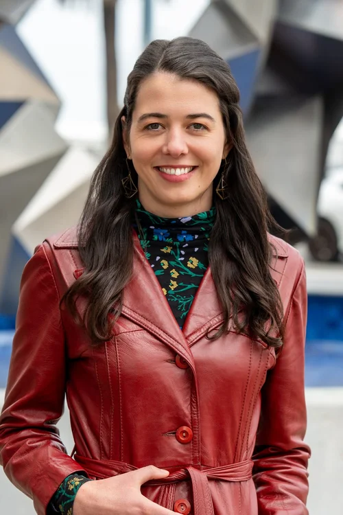 Team headshot of a woman in a red leather jacket outdoors in the Bay Area