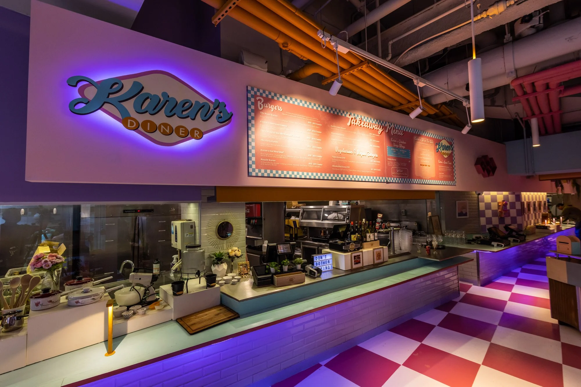 Interior of a diner named Lauren's Diner with neon sign, menu board, and checkered floor.