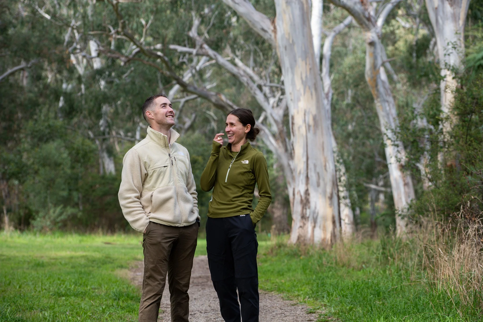 Ava and Michael stand smiling on a bush trail