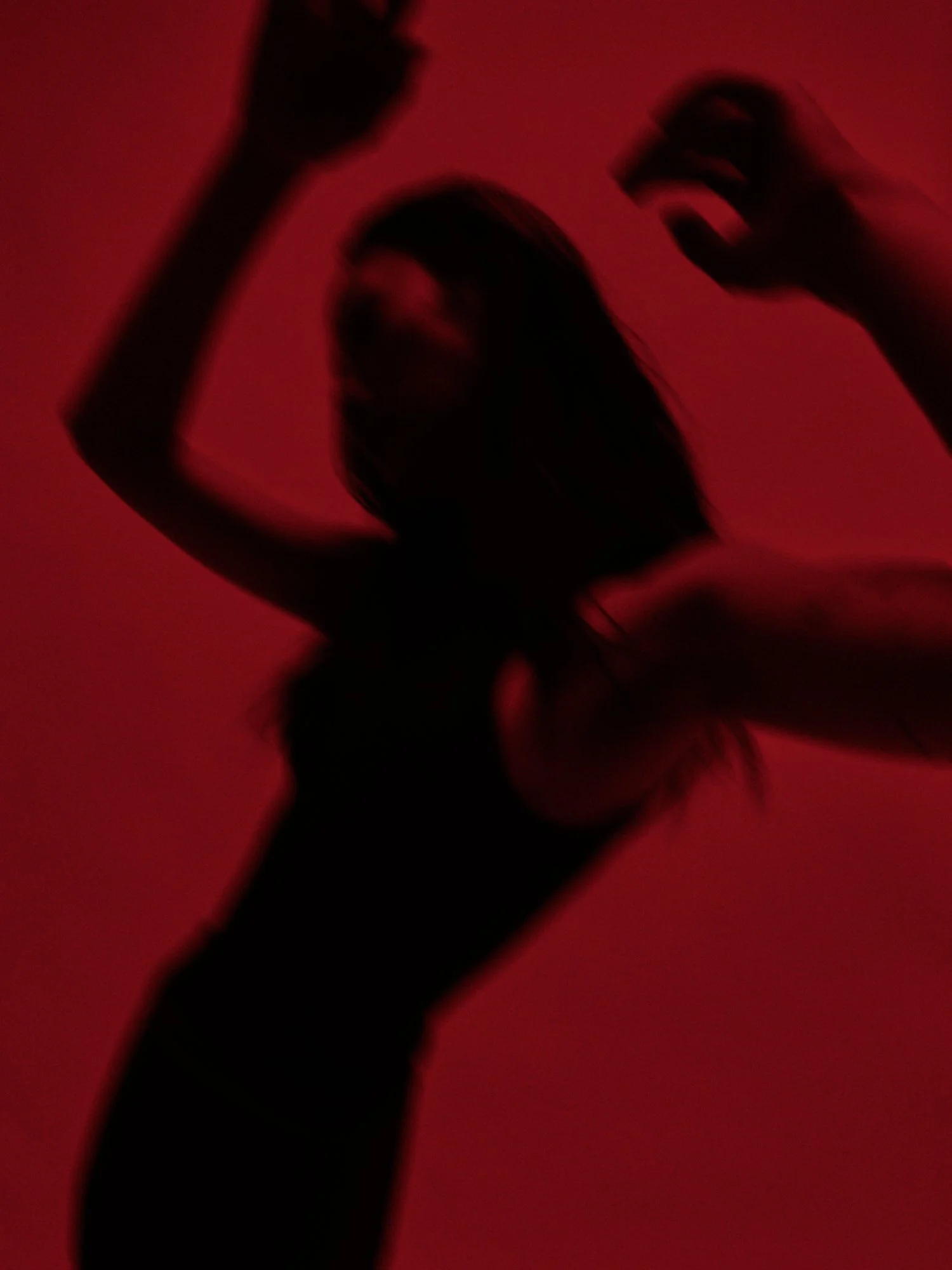 A WOMAN IN MOTION BLUR MOVES THROUGH A WIDE-ANGLE RED FRAME. SHOT AS PART OF A CAMPAIGN FOR A. DI GAETA SHOES IN MILAN ITALY BY PHOTOGRAPHER GRAYSON LAUFFENBURGER