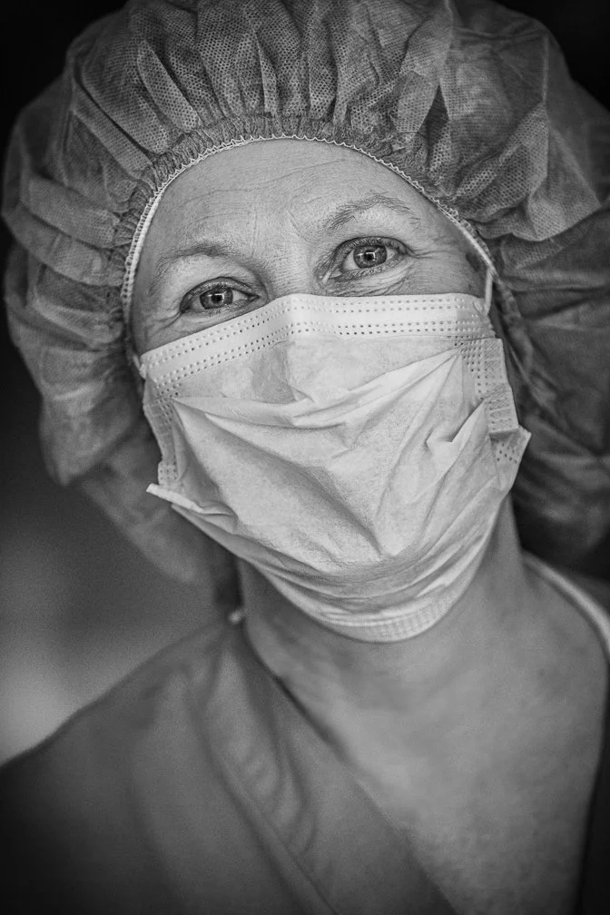 A powerful portrait of a nurse smiling behind her face mask, showcasing her optimism during the pandemic.