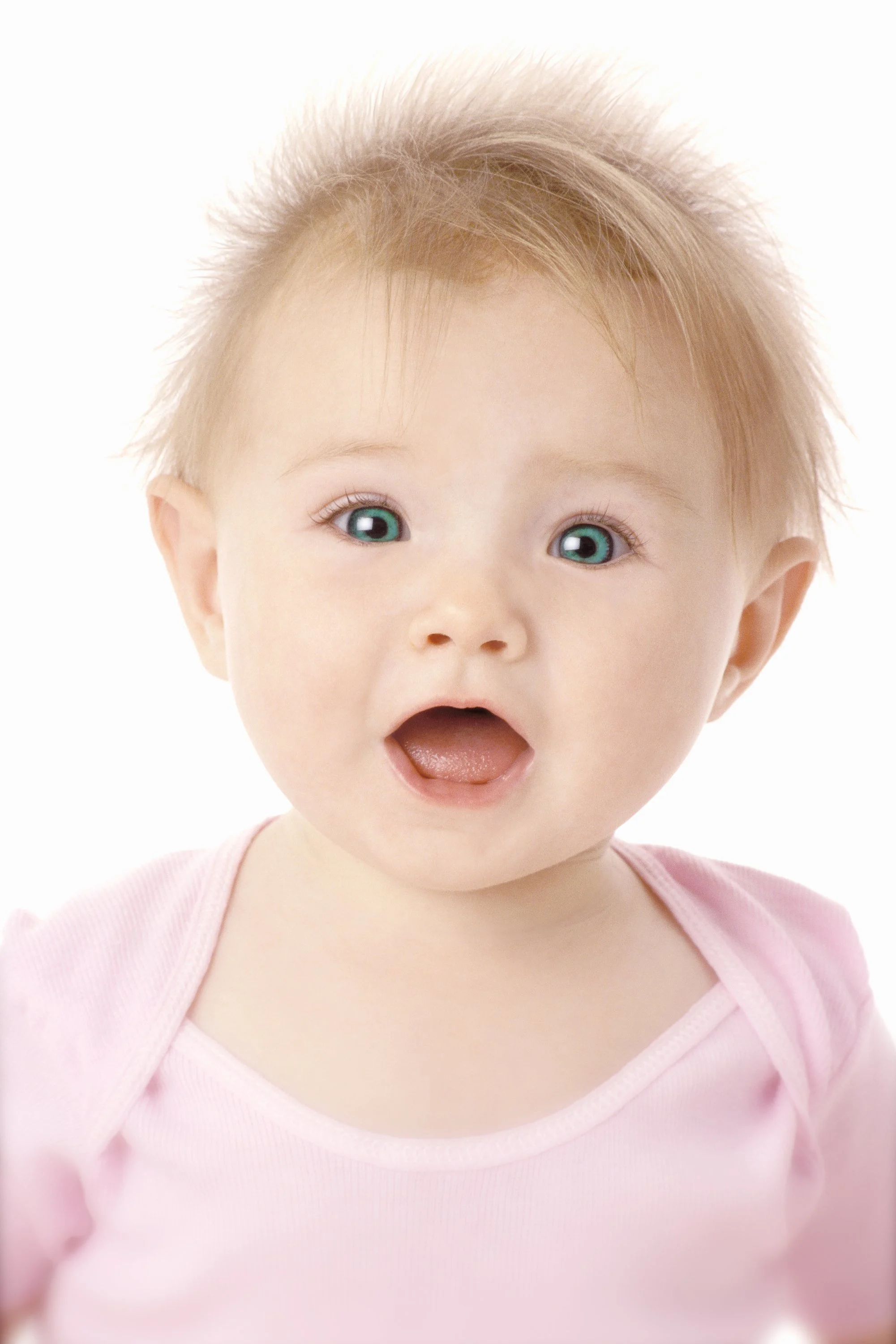 A close-up studio portrait of a smiling baby wearing a soft pink shirt against a white background.