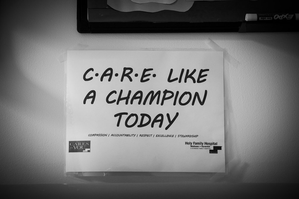 A small sign in the Covid ICU reads 'CARE LIKE A CHAMPION TODAY,' offering encouragement during difficult times.