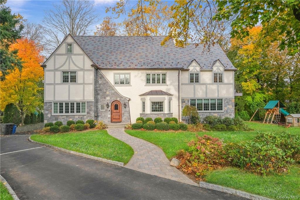 Beautiful exterior renovation. We defined the home style with traditional Tudor timbering, accented with stone and custom mahogany door. Replaced all windows, slate roof and built a two addition to the right side of home.