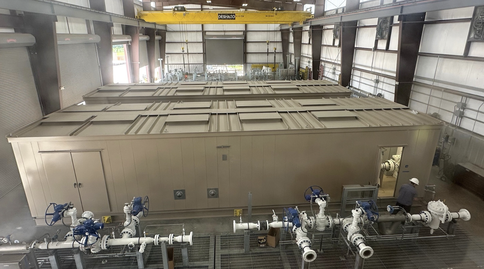 Chemtec Mission Critical fabrication shop with high ceilings overhead cranes and large modular data center, Oil and Gas, and CO2 enclosures under assembly, Willis Texas