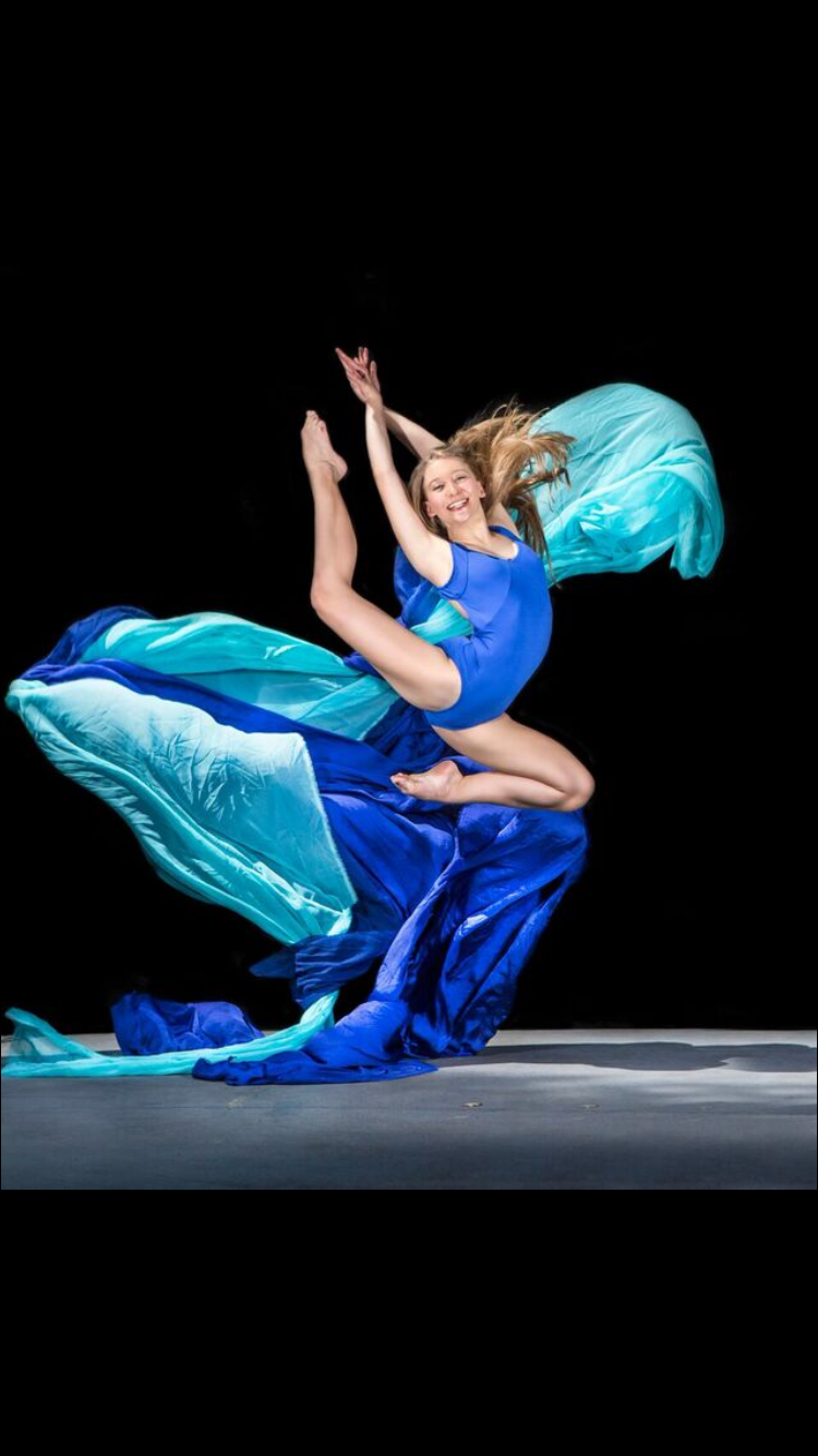 Sarah Childs leaping with blue and teal silk