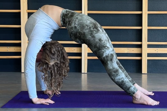 Sarah in a full backbend on a purple yoga mat