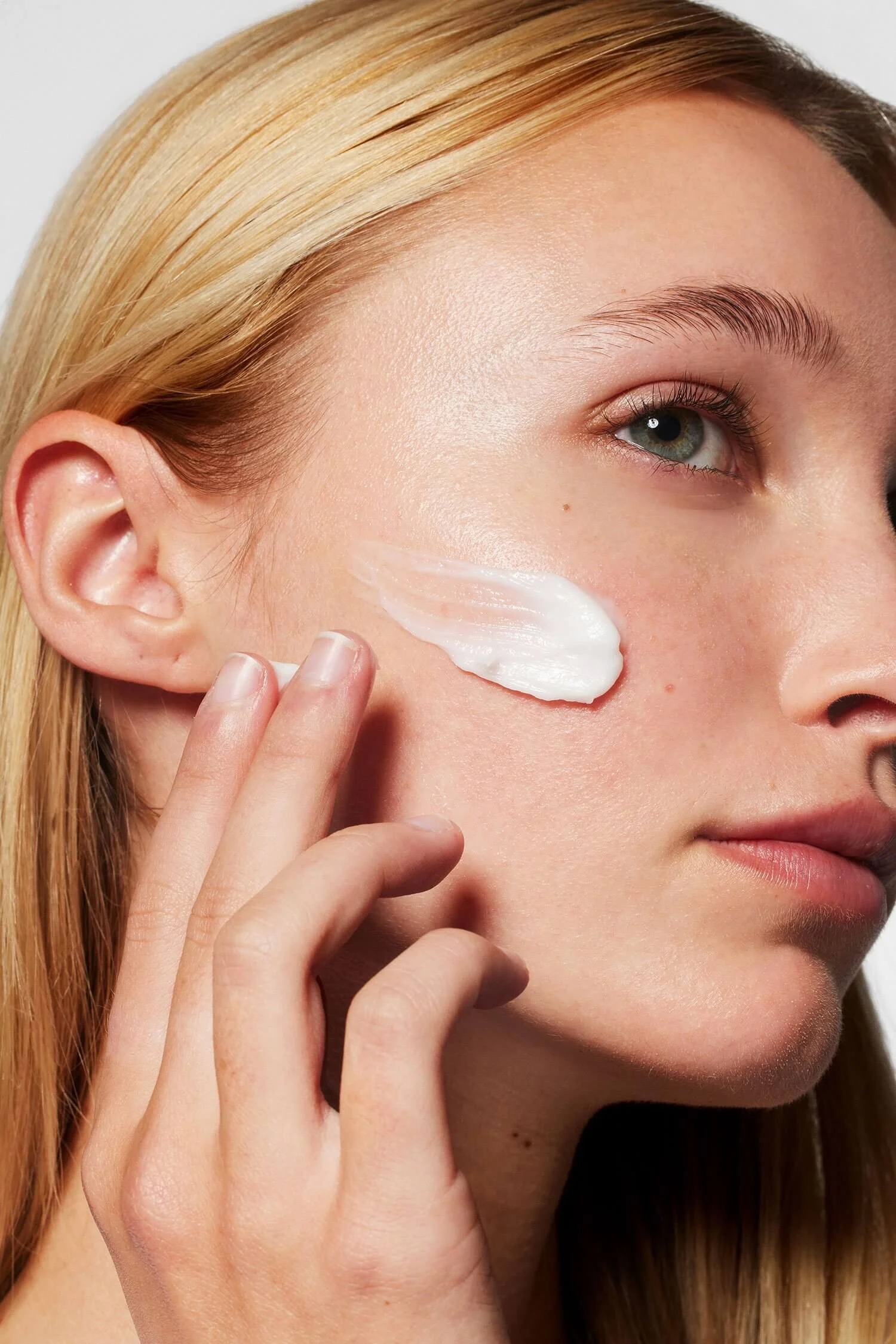 Model with moisturizer on the right side of face