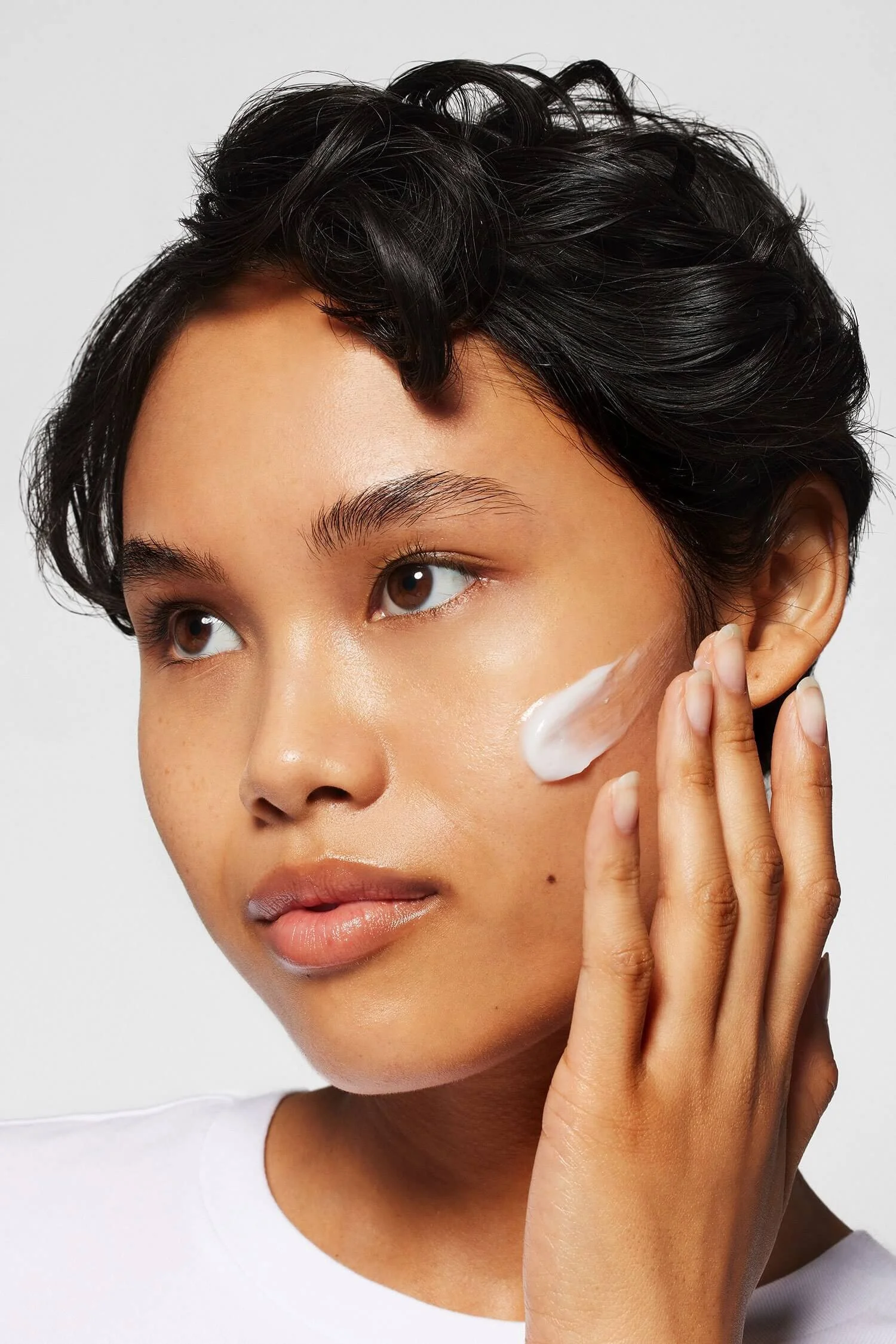 Model with moisturizer on the left side of face