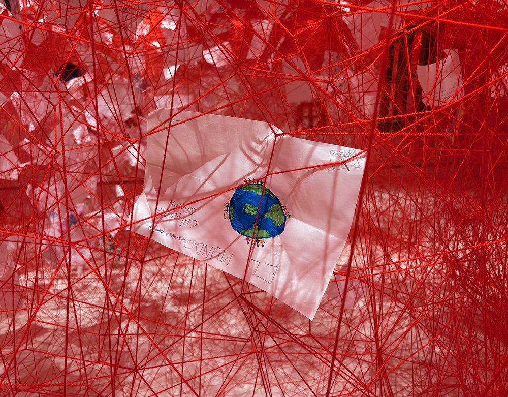 Caught in the web of yarn were many drawings by children who participated in community sessions.