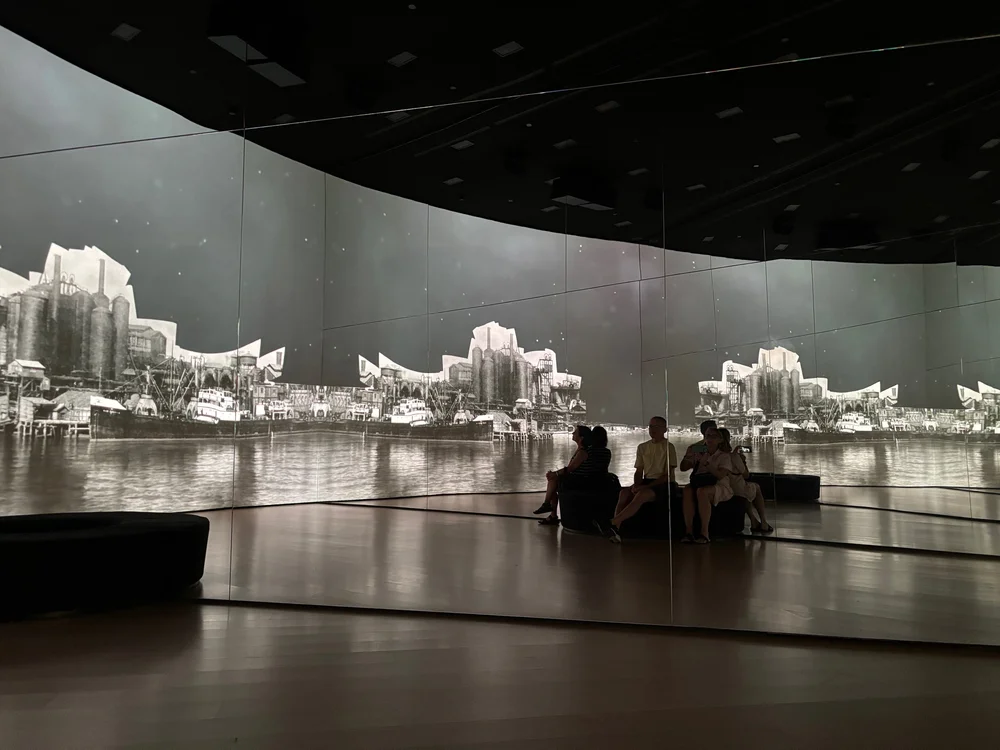 Watching a moving montage of the history of Bilbao’s waterfront. From shipping glory days, through decline and abandon, to the Guggenheim today.