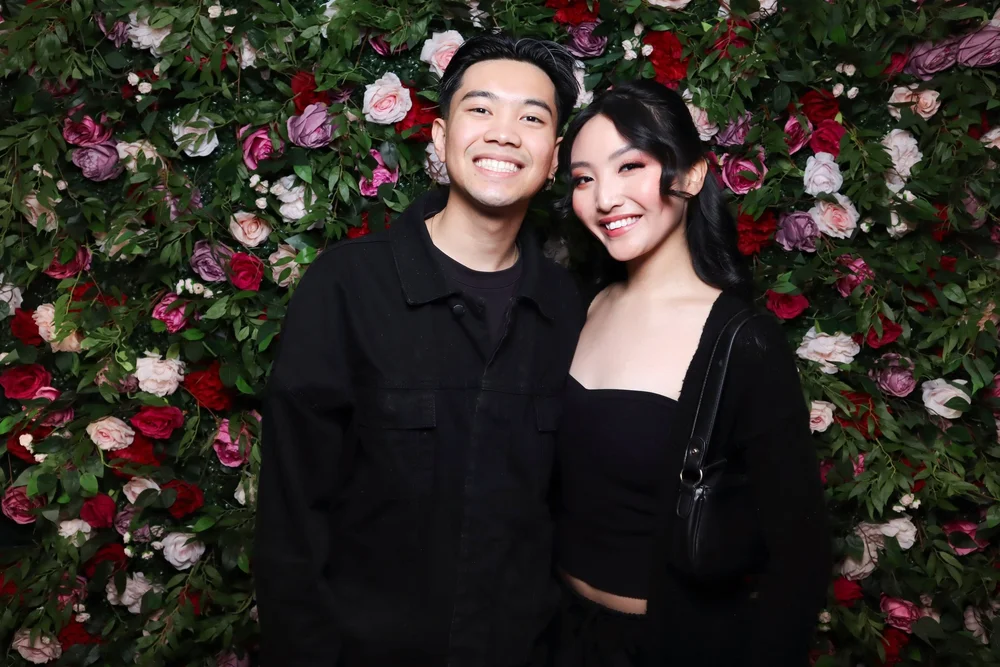 A couple in front of the Secret Garden flower wall