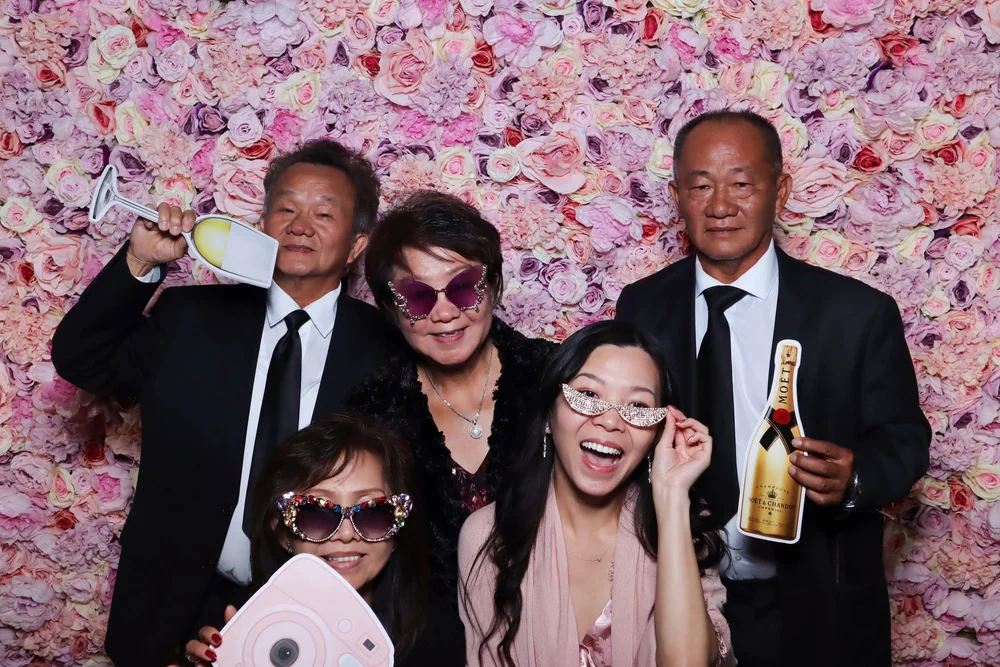 A group of guests in front of the Pastel Dreams flower wall