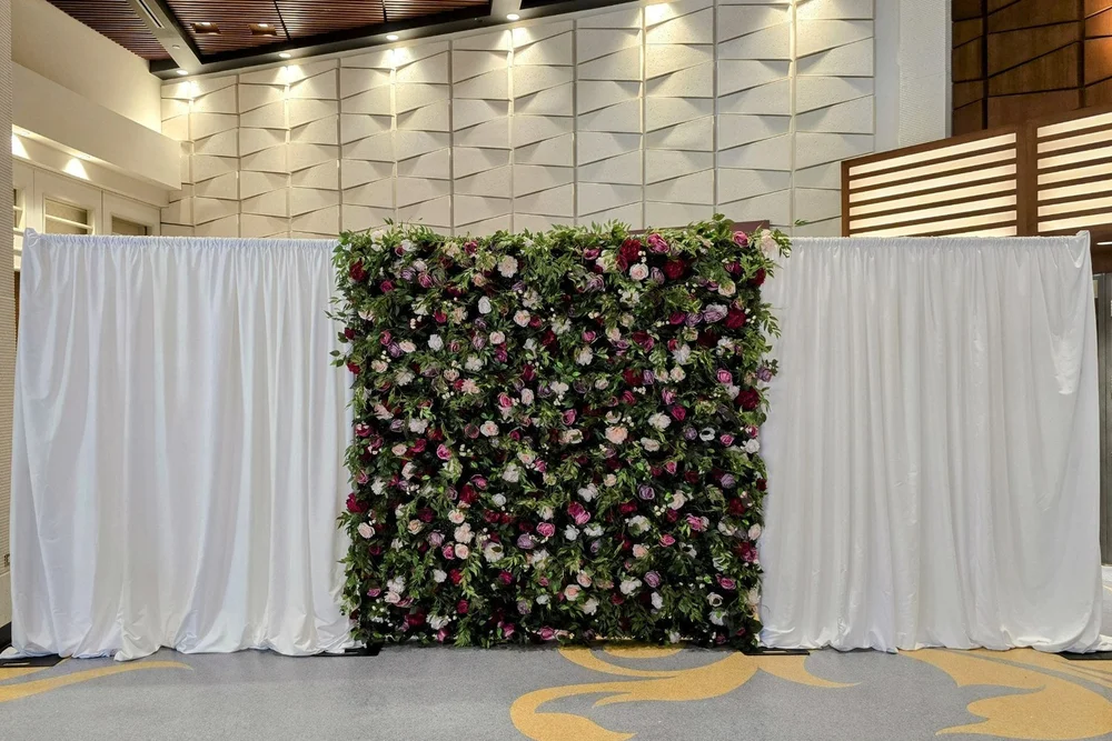 White draping on either side of a flower wall at a Winnipeg venue
