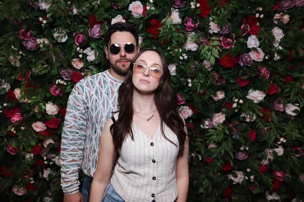 A couple posing in front of the Secret Garden rose wall