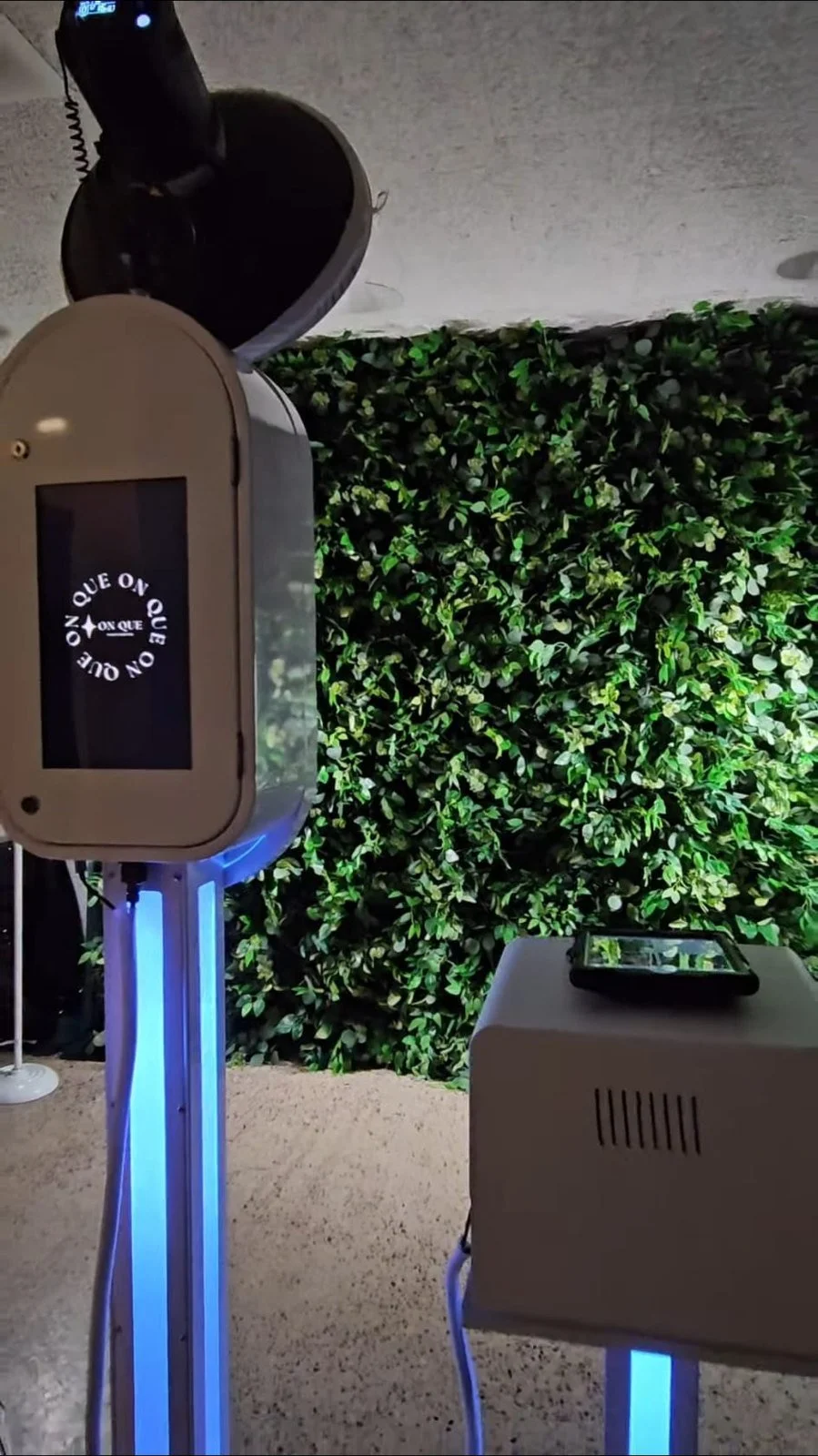 The Aura booth in front of a greenery wall at a Winnipeg event