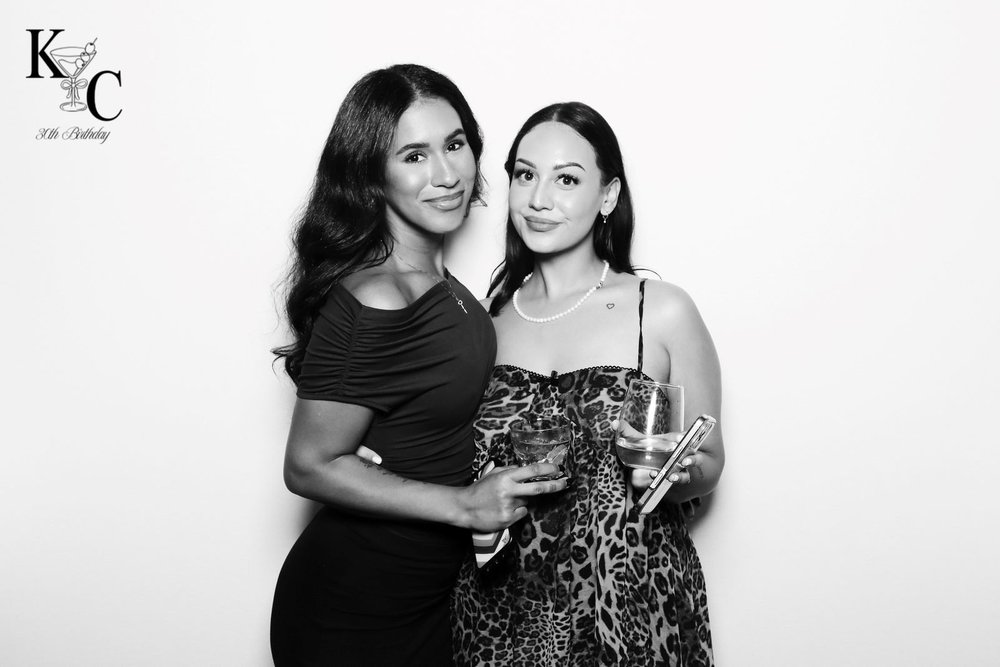 Two guests at a Winnipeg 30th birthday in a black and white glam portrait by On Que Photo Booth