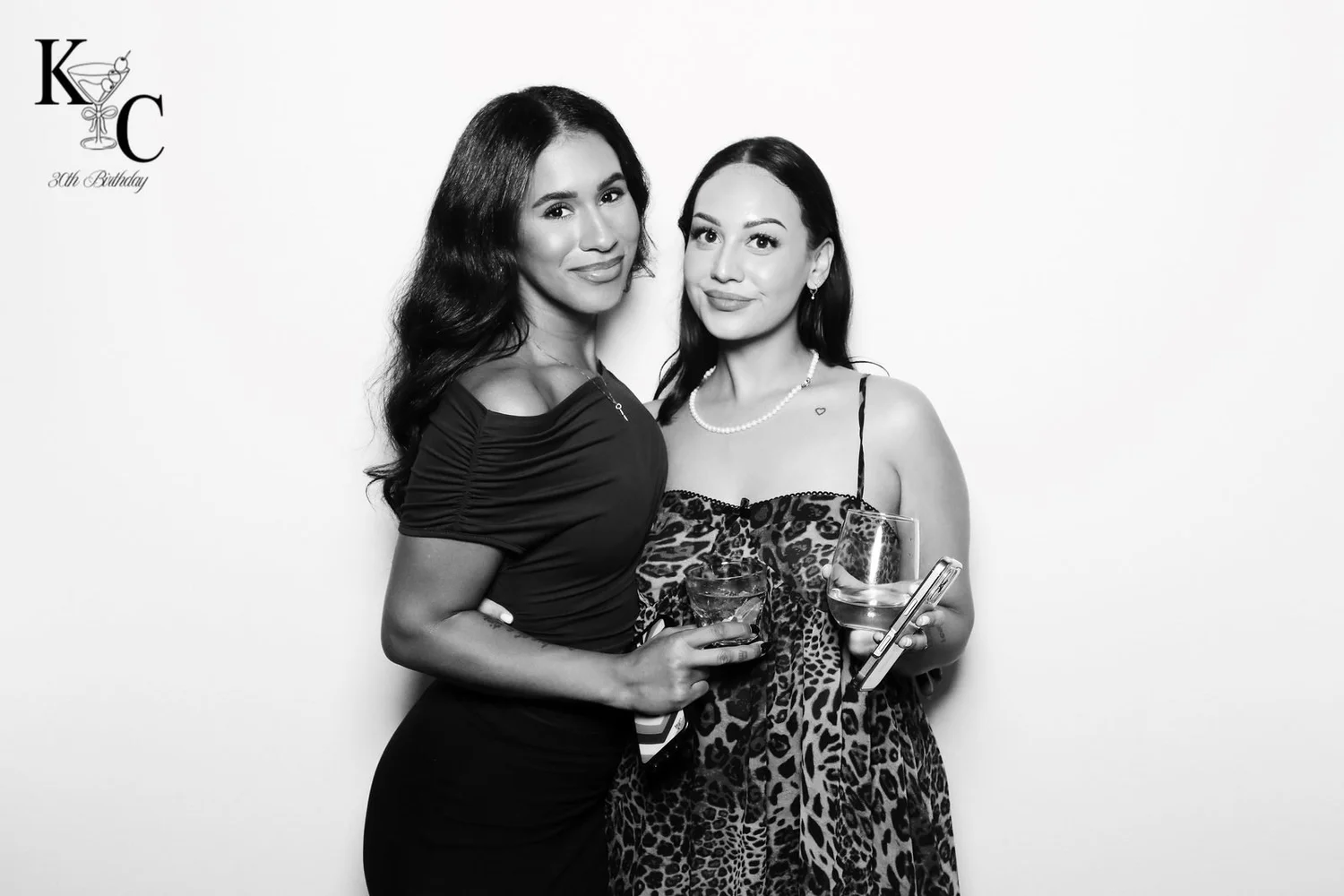 Two guests at a Winnipeg 30th birthday in a black and white glam portrait by On Que Photo Booth