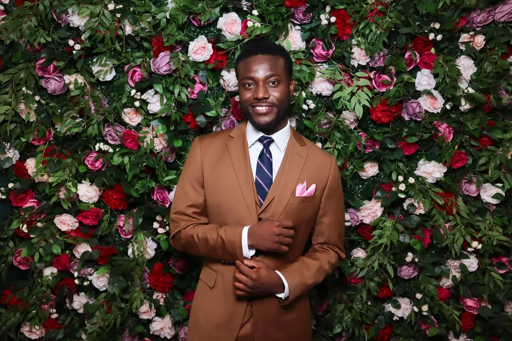 A guest in front of the Secret Garden flower wall