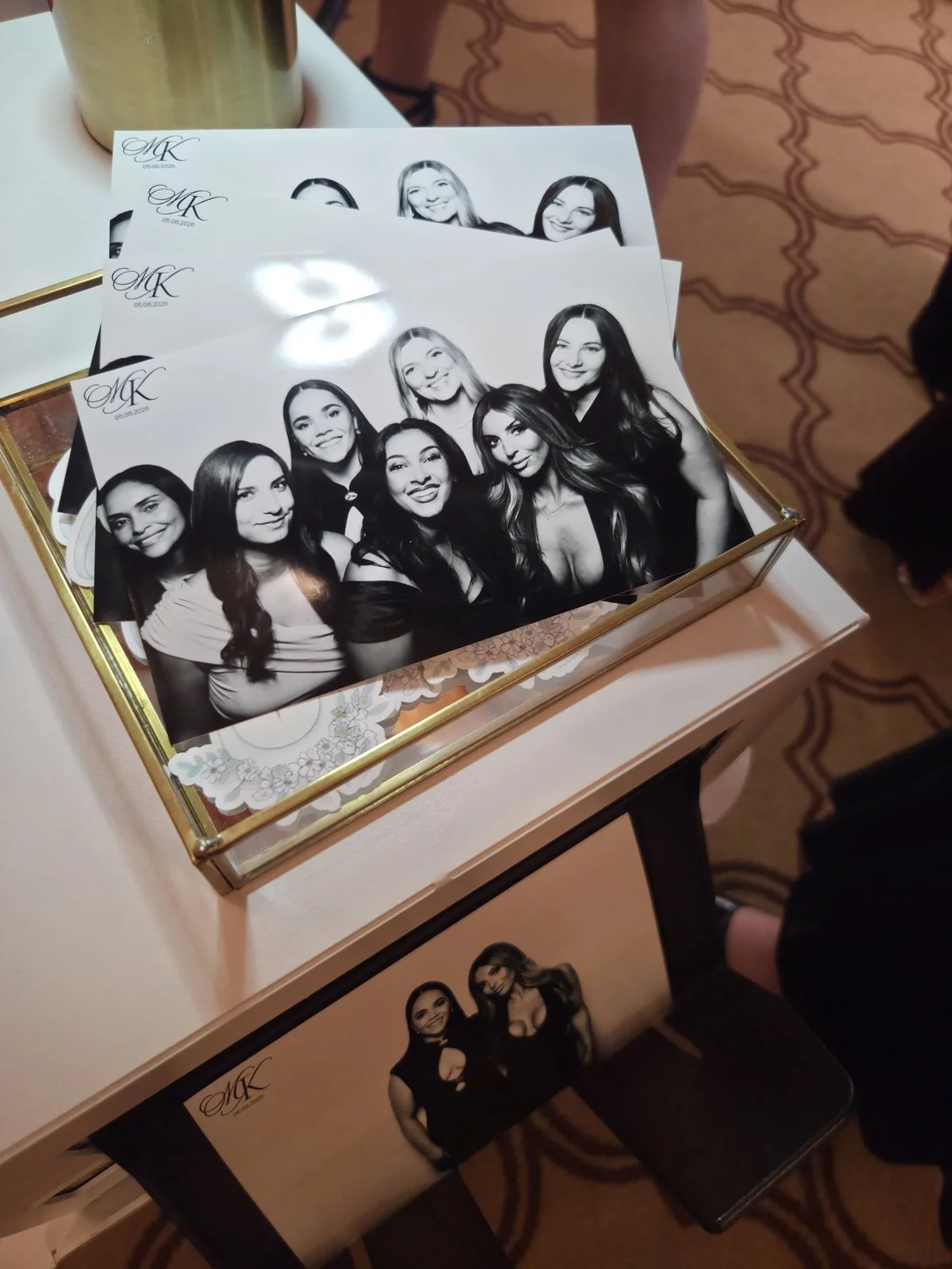A fan of monogrammed black and white glam prints on a gold tray at a Winnipeg wedding