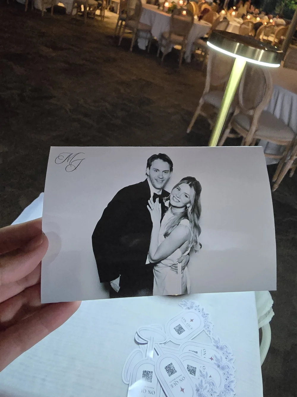 A hand holding a black and white glam print of the married couple at a Winnipeg wedding