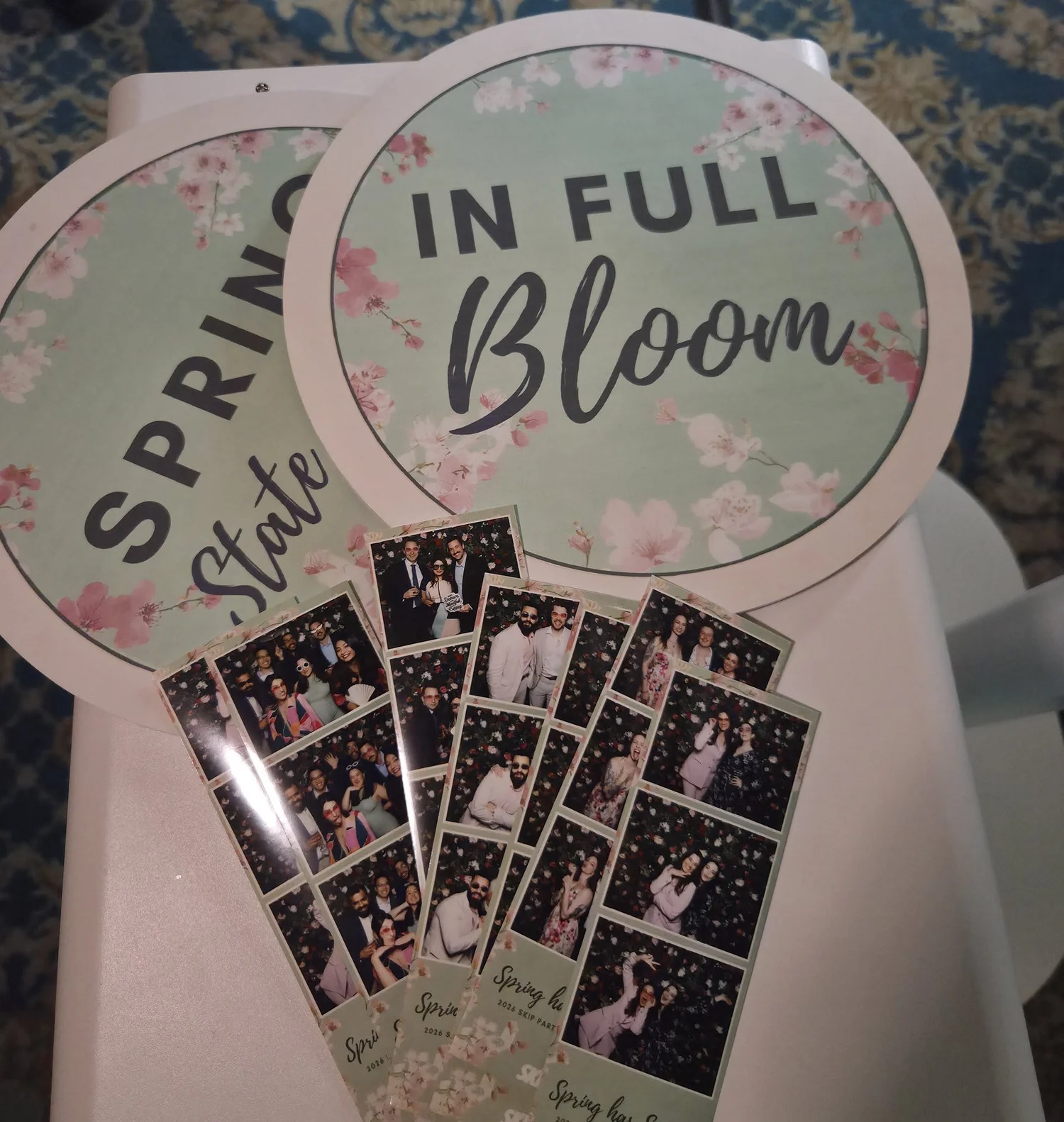 Custom round props printed with the client's In Full Bloom theme, beside branded prints