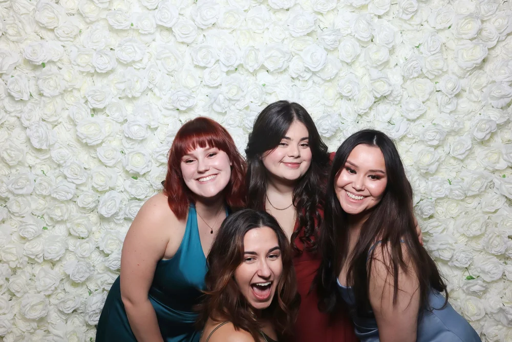 Friends posing in front of the Rose Blanc flower wall