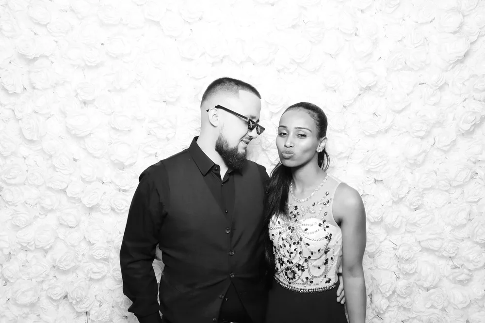 A couple in front of the white rose flower wall