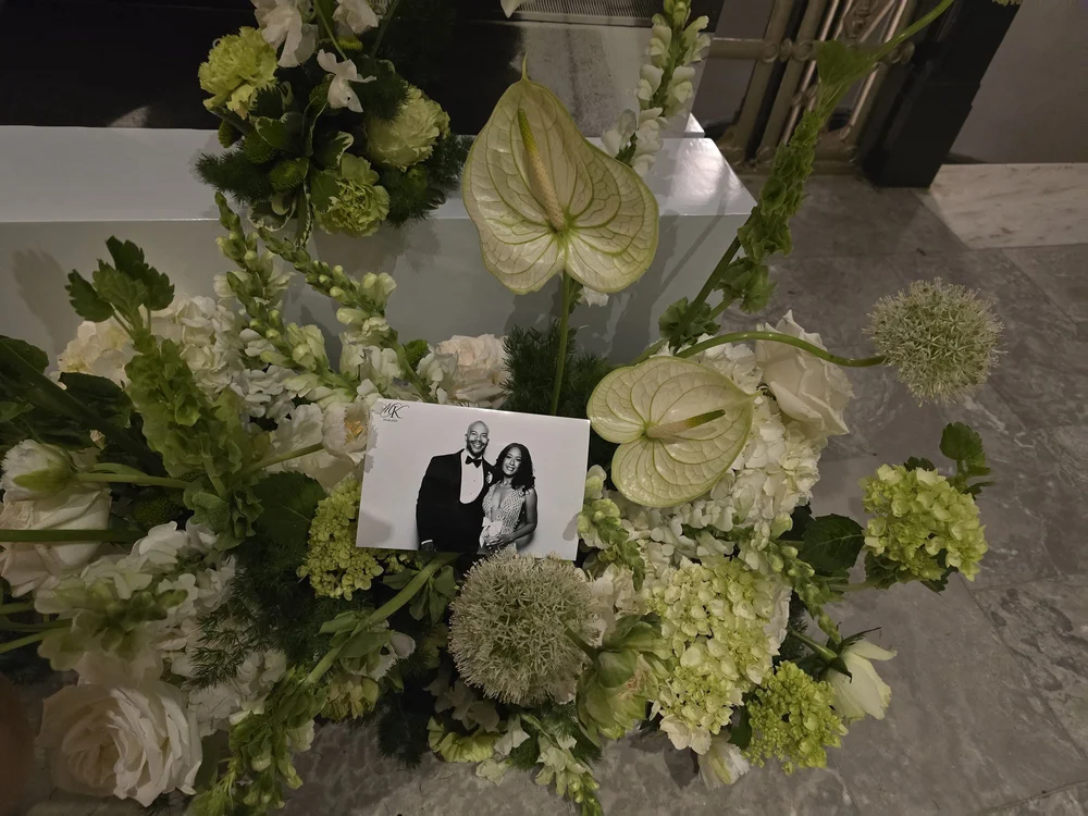 A black and white glam print resting in white wedding florals