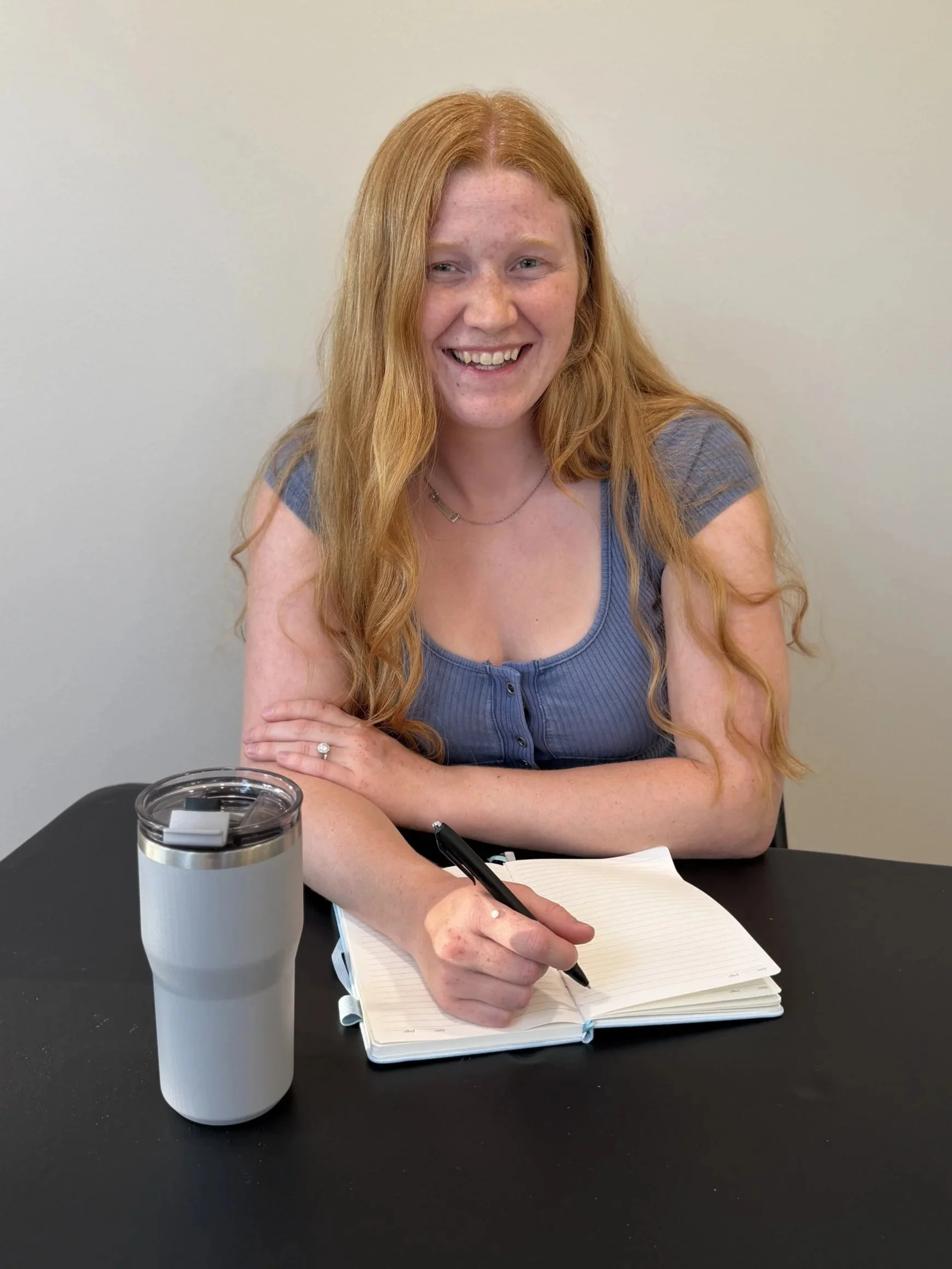 Couples Therapist Miriam Ninmann sits at a table with a warm smile.