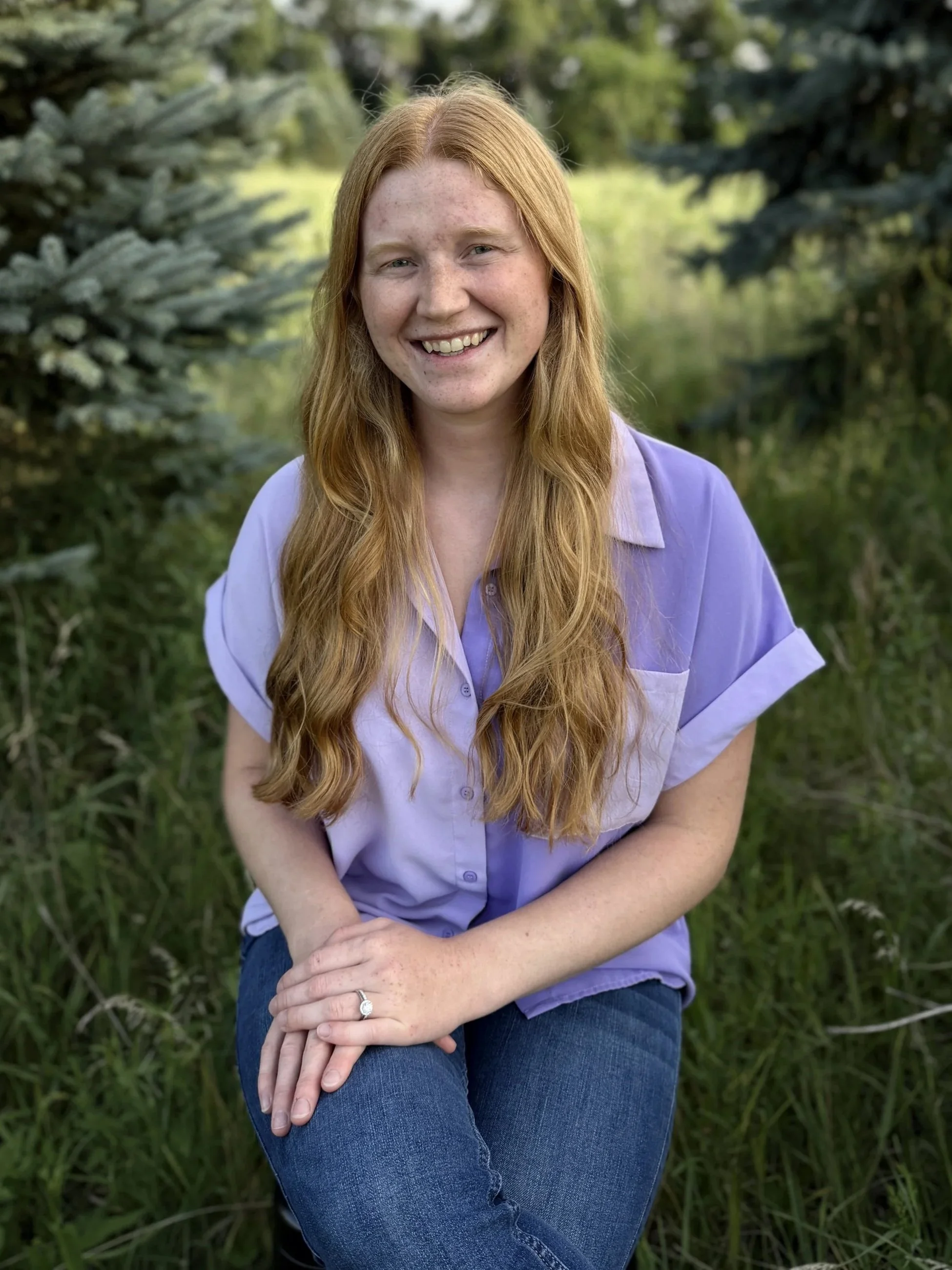 Couples therapist in milwaukee, Miriam Ninmann sits in wooded area.