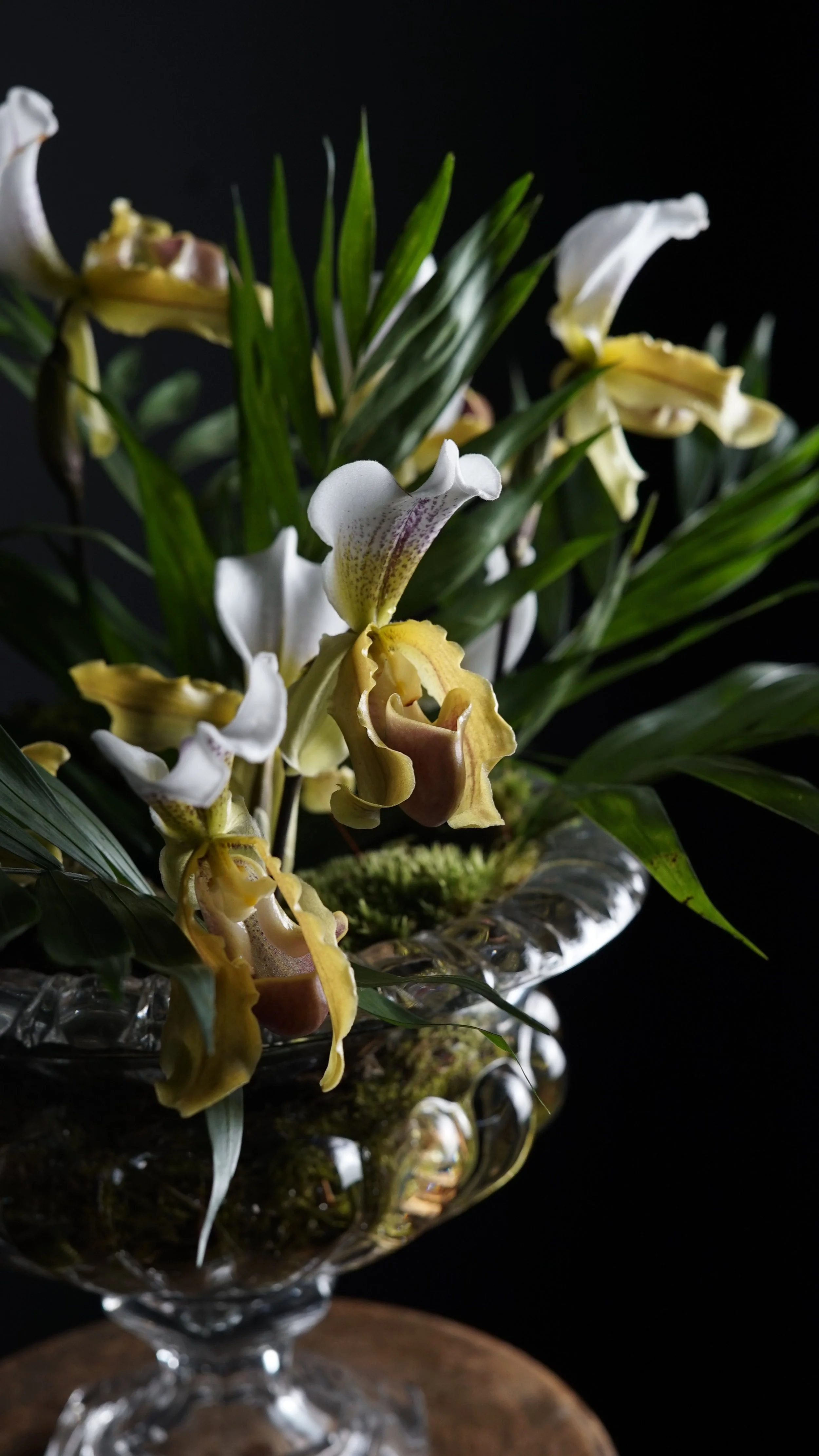 Ramo de orquídeas blancas y amarillas en un florero de cristal