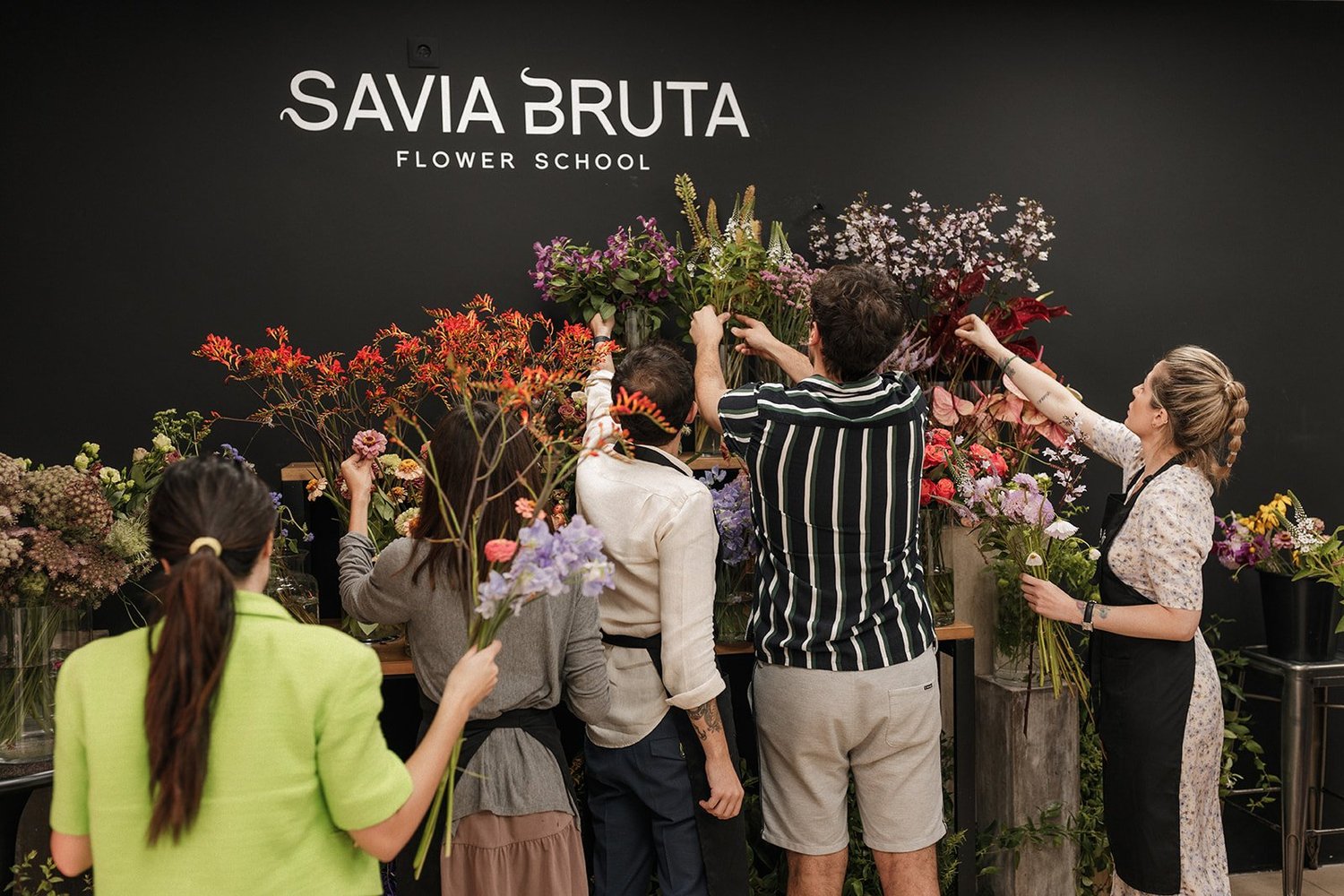 Personas eligiendo flores en la escuela Savia Bruta