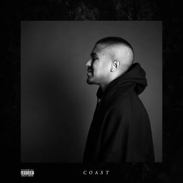 Profile view of a young man with a buzz cut hairstyle, wearing a black hoodie, on a dark background with a gray to black gradient, album titled 'COAST' at the bottom.
